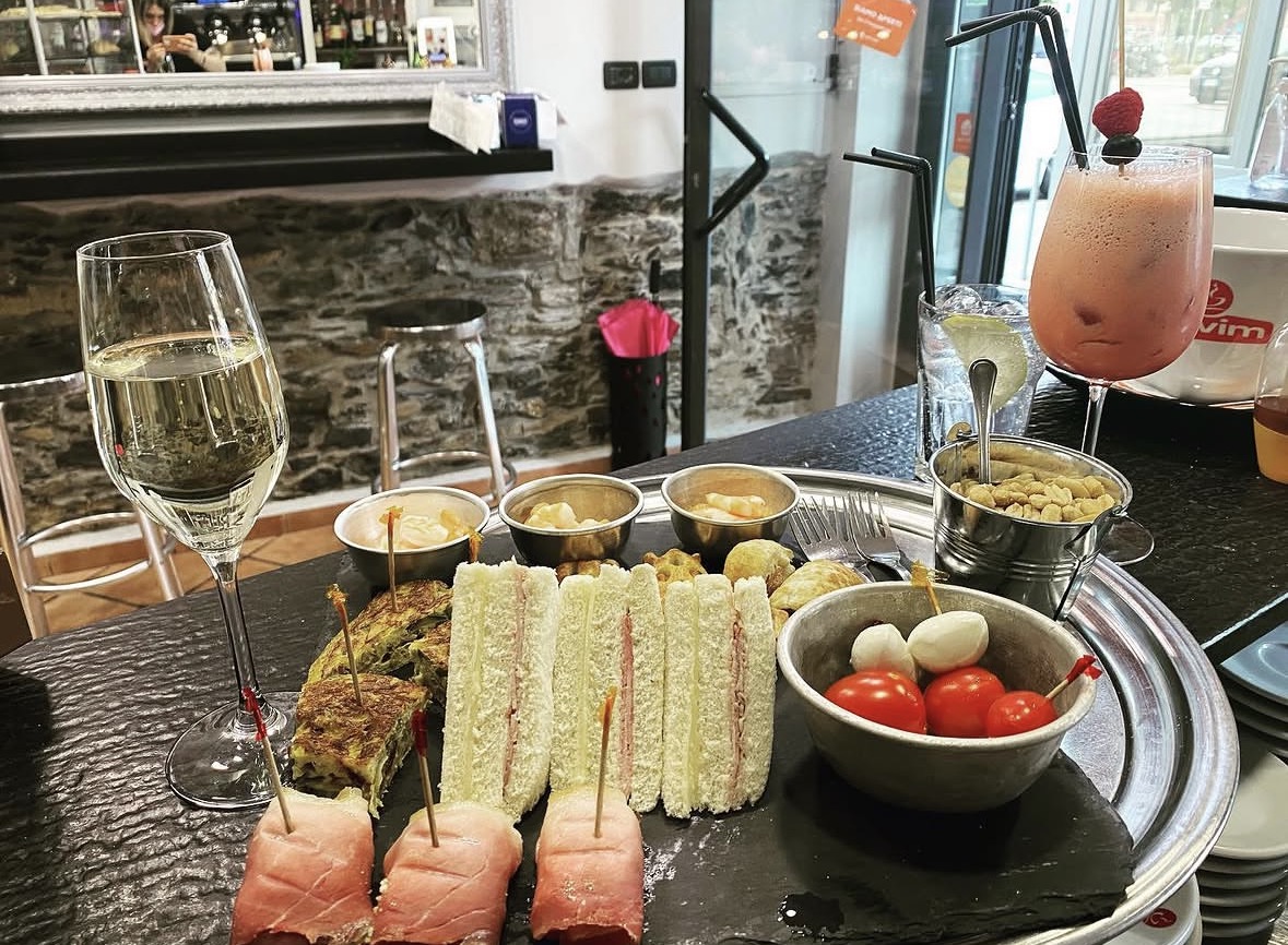 Aperitivo al bar con stuzzichini e calice di vino